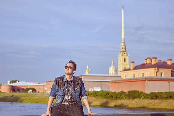Young hipster sits in historic center of Saint-Petersburg, Russia. - Foto, afbeelding