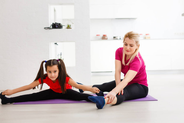 Madre e hija haciendo ejercicio en casa - Foto, Imagen