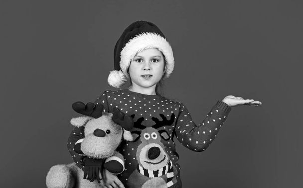 Try it. xmas party surprise. winter holiday mood. surprise for new year holiday. everyone will get a present. small girl santa with toy, copy space. kid with purchase. christmas shopping and sale - 写真・画像