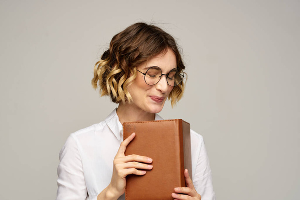 woman with notepad in hands business work beige background glasses hairstyle - Photo, Image