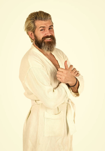 Relaxing at home. Man in terry bathrobe in the bathroom. mature man wear bathrobe relaxing at spa. Caucasian bearded guy wearing white bathrobe. hotel spa vacation. man in underwear. Hygiene - 写真・画像