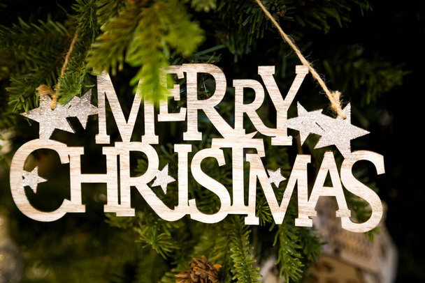 Un primo piano di allegra decorazione di legno di Natale appeso su un albero di Natale - Foto, immagini