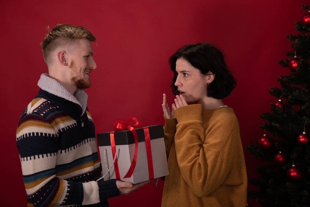 Молодой человек представляет плохие подарочные коробки расстроить подругу, неоправданные ожидания - Фото, изображение
