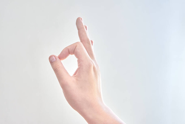 A closeup of male hand gesture of okay against a white background - Foto, Imagem