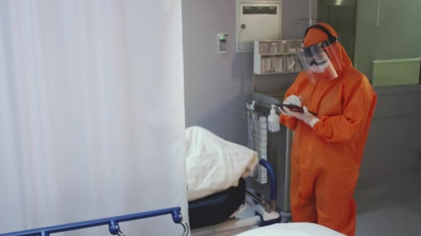 Arzt misst die Temperatur von Coronavirus-Patienten und notiert sie - Filmmaterial, Video