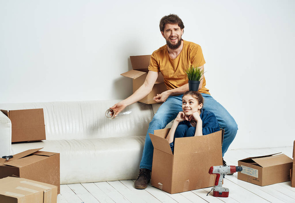 Hombre y mujer en una nueva caja de apartamentos con cosas interiores - Foto, Imagen