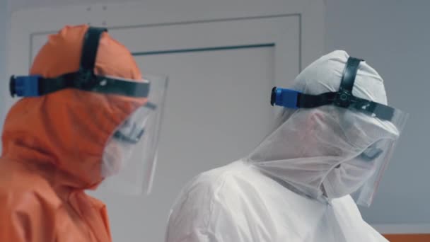 Slowmo - Врачи в защитных костюмах консультируются со статусом коронавируса - Кадры, видео