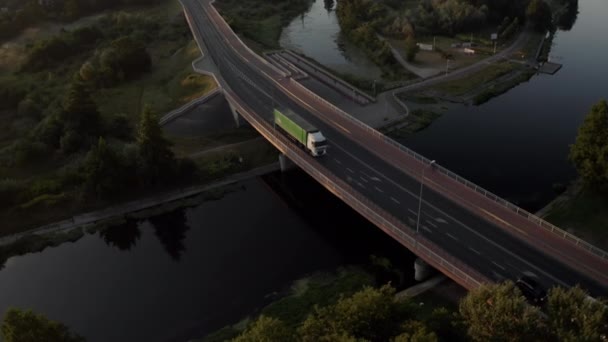 Φορτηγό οδήγηση πάνω από μια γέφυρα τριών λωρίδων ενάντια σε μια όμορφη ανατολή - Πλάνα, βίντεο