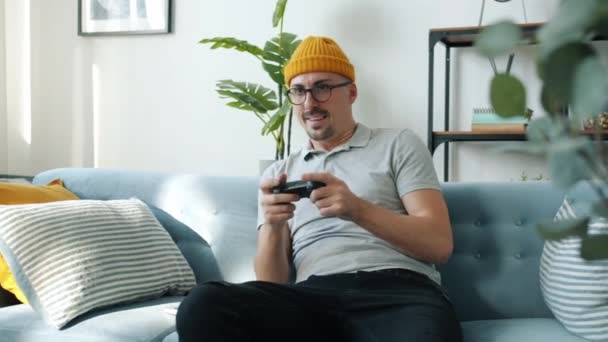 Cheerful guy enjoying video game playing alone winning celebrating victory - Záběry, video