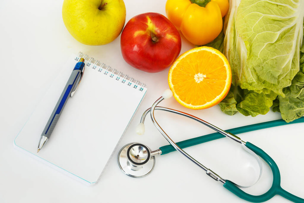 Nutrition and healthy eating. Fruits, vegetables, juice and stethoscope - Photo, image