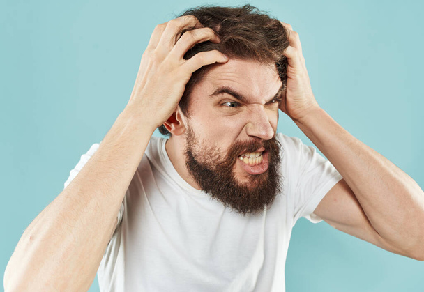 Эмоциональный бородатый мужчина на синем фоне обрезанный вид жестикуляции руками - Фото, изображение