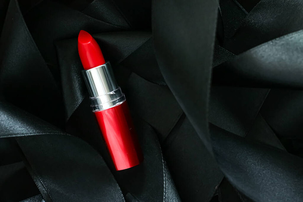 黒シルクの背景に赤い口紅、豪華な化粧品と美しさの化粧品 - 写真・画像