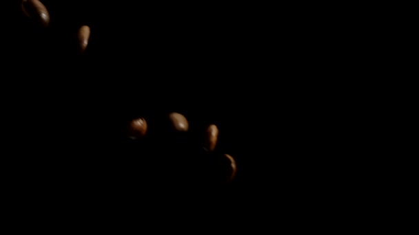 Premium koffiebonen gieten naar beneden van beide zijden in slow mo, zwarte achtergrond - Video