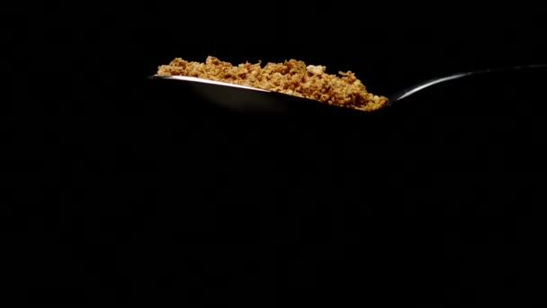 Bread crumbs falling from spoon in slow motion isolated on black background - Кадри, відео