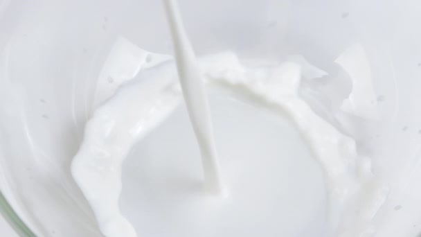 Gros plan délicieux lait sain est versé dans un bol en verre au ralenti, boire - Séquence, vidéo