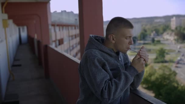 Jóvenes caucásicos fumando cigarrillo en edificio residencial de gran altura de la ciudad interior  - Imágenes, Vídeo