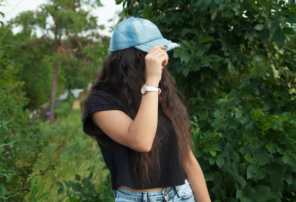 Mladá dívka v džínové čepici, venku. - Fotografie, Obrázek