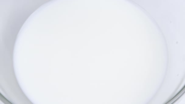 Close-up delicioso leite desnatado saudável é derramado em tigela de vidro em câmera lenta - Filmagem, Vídeo