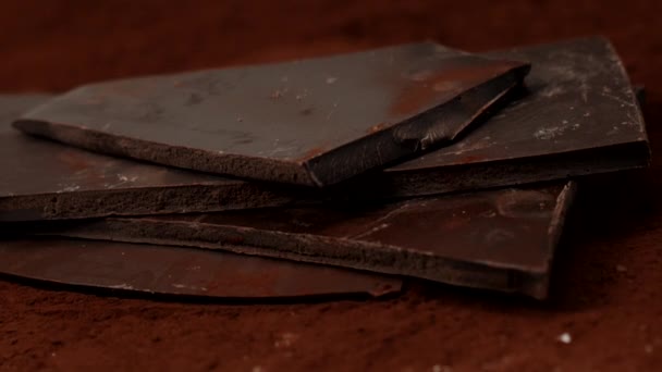 Dark chocolate stack in cocoa powder shattered by stabbing closeup, slow motion - Footage, Video