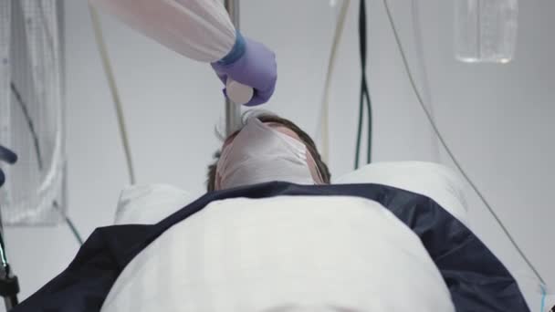Lekarz mierzący temperaturę u pacjentów z koronawirusem i odnotowujący ją - Materiał filmowy, wideo
