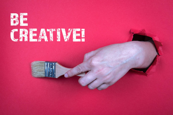 Seien Sie kreativ. Maler pinseln in Frauenhand. Roter Hintergrund - Foto, Bild