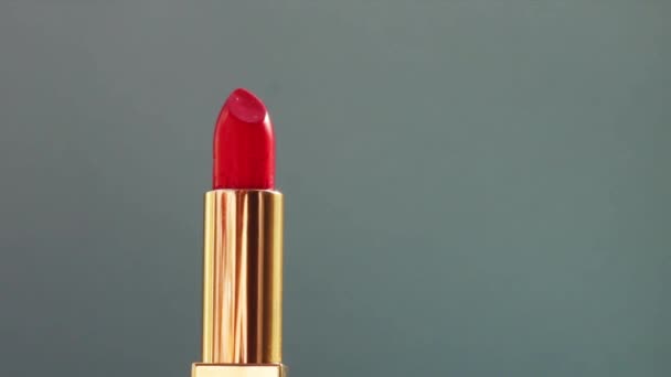 Batom vermelho de luxo em tubo dourado sobre fundo de cor e clarões brilhantes, produto de maquilhagem de luxo e cosméticos de férias para a marca de beleza - Filmagem, Vídeo