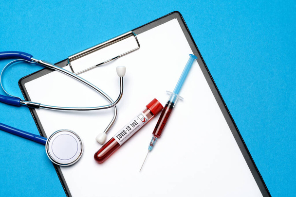Healthcare concept - Covid-19 negative blood test tube, stethoscope, syringe and clipboard with blank sheet - Valokuva, kuva