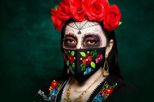 Catrina hímzett arcmaszkkal. A Halottak Napjának megünneplésére készült, színes, kézzel hímzett maszkot viselő lány.. - Fotó, kép