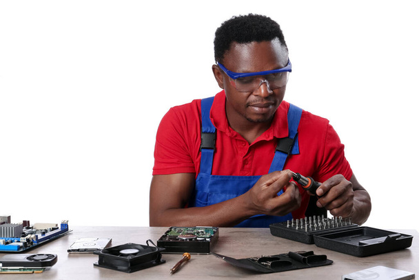 Técnico afroamericano reparando computadora sobre fondo blanco - Foto, imagen