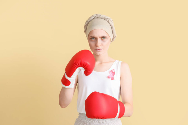 カラーを背景にボクシング手袋で化学療法後の女性。癌との戦い - 写真・画像