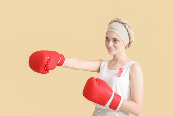 Mujer después de la quimioterapia en guantes de boxeo sobre fondo de color. Lucha contra el cáncer - Foto, Imagen