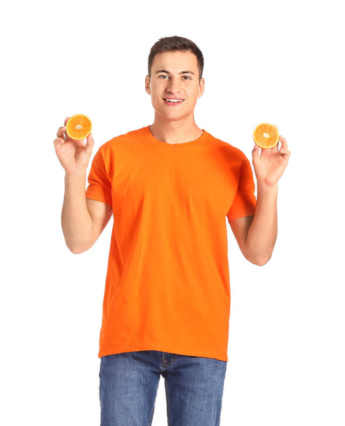 Handsome man with ripe orange on white background - Photo, image