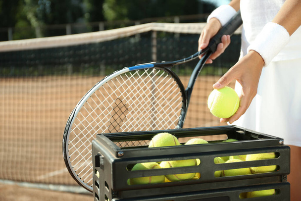 Sportswoman playing tennis at court on sunny day, closeup - Zdjęcie, obraz