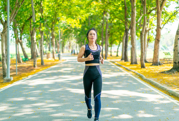 Asian woman jogging and running at park - Фото, изображение