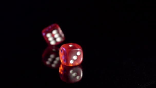 Movimiento lento de balanceo cubos de juego en la mesa negra.Rolling dados de casino rojo - Imágenes, Vídeo