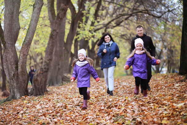Junge Familie bei einem Spaziergang im Herbstpark an einem sonnigen Tag. Das Glück, zusammen zu sein. - Foto, Bild