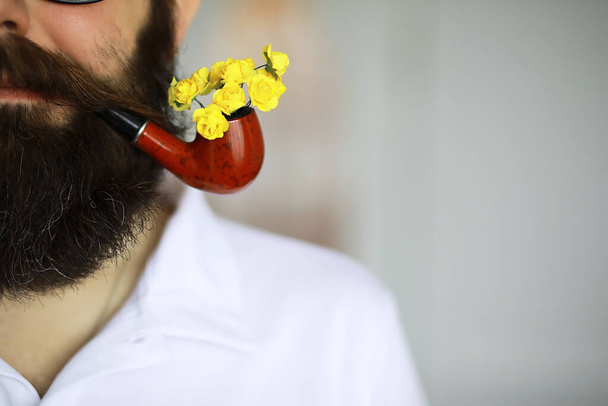 Hombre guapo o leñador, hipster barbudo, barba y bigote en camisa con pipa humeante - Foto, Imagen