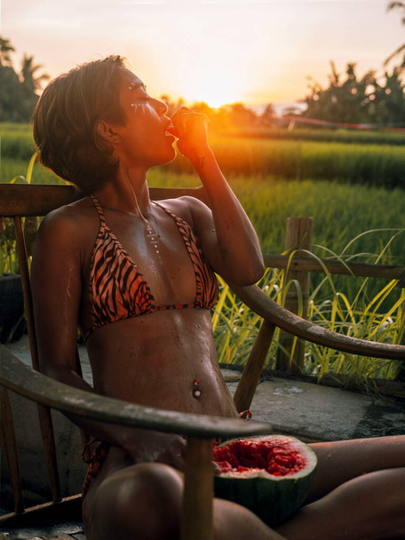 Beautiful girl wearing swimsuit eating watermelon - Photo, image