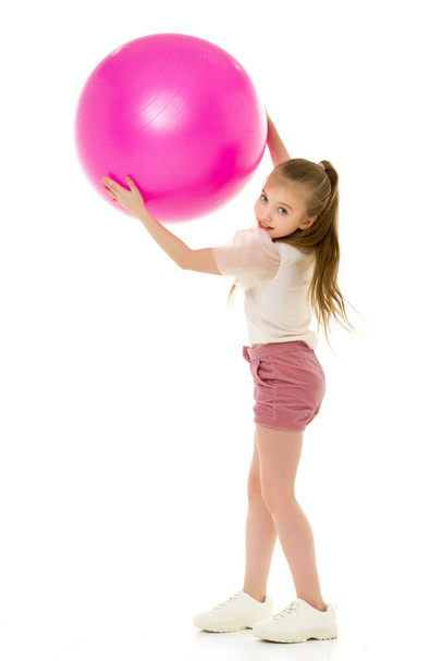 Little girl plays with a big ball for fitness - Фото, изображение
