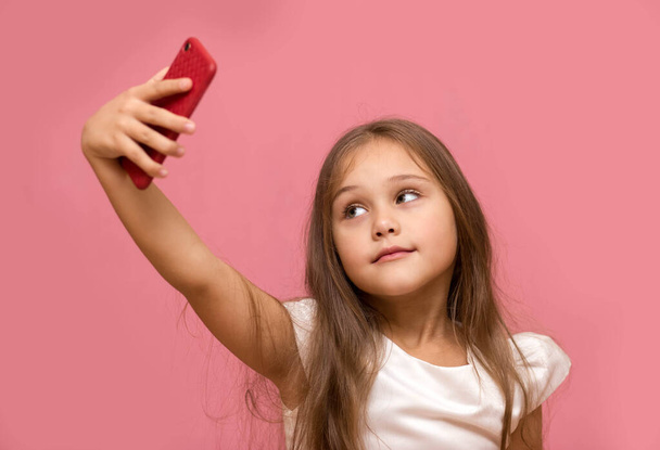 little girl with long hair takes a selfie on the phone - Foto, immagini