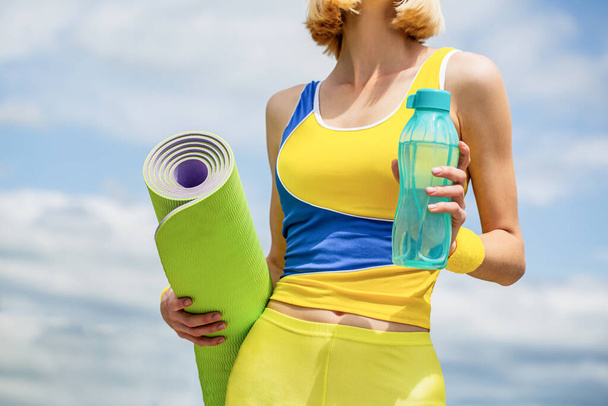 Jóga matrac és vizes palack. Fitness lány jóga szőnyeggel - Fotó, kép