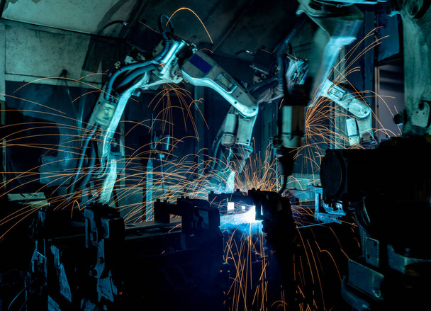 Robôs de soldagem de equipe representam o movimento na indústria de peças automotivas - Foto, Imagem
