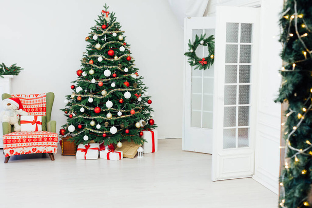 Χριστουγεννιάτικο δέντρο με δώρα δίπλα στο τζάκι για τη νέα διακόσμηση του σπιτιού - Φωτογραφία, εικόνα