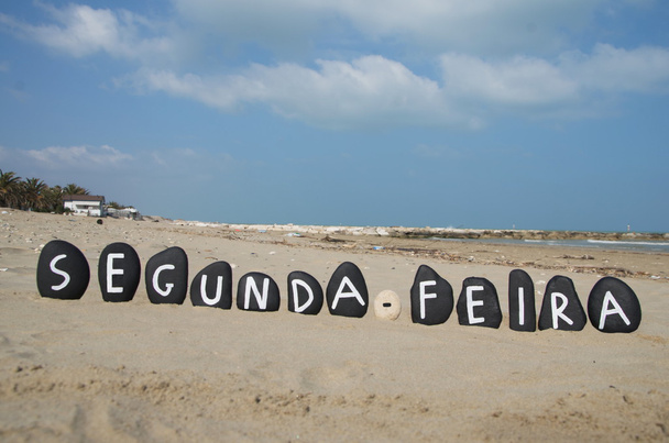 maandag in de Portugese taal op zwarte gekleurde stenen op het strand - Foto, afbeelding