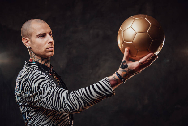 Cheerful coash in modern suit poses with soccer ball - Photo, Image