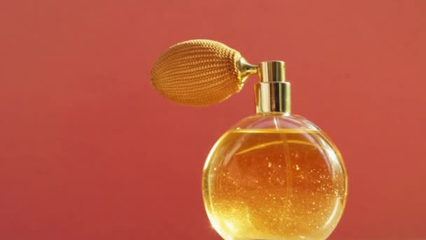 Złota butelka perfum i błyszczące lekkie flary, elegancki zapach jako luksusowy produkt dla marki kosmetycznej i kosmetycznej  - Materiał filmowy, wideo