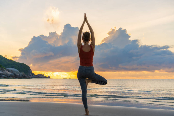 Zdrowa Joga kobieta styl życia zrównoważony praktykowanie medytacji i energii jogi na plaży w godzinach porannych i zachody słońca na świeżym powietrzu charakter. Koncepcja zdrowego życia - Zdjęcie, obraz