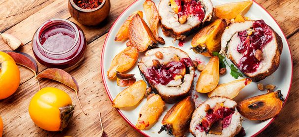 Baked pork roll with autumn persimmon.Meat stuffed with fruits. - Photo, Image