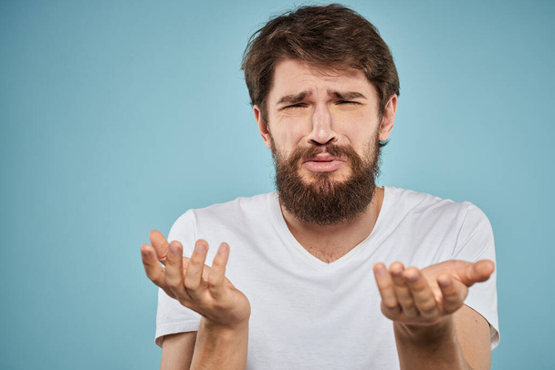 Бородатый человек эмоции белые футболки стиль жизни жесты с руками синий фон - Фото, изображение