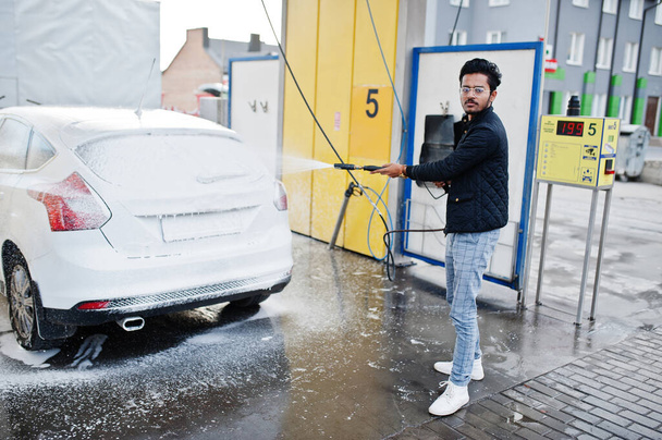 South asian man or indian male washing his white transportation on car wash. - Foto, immagini